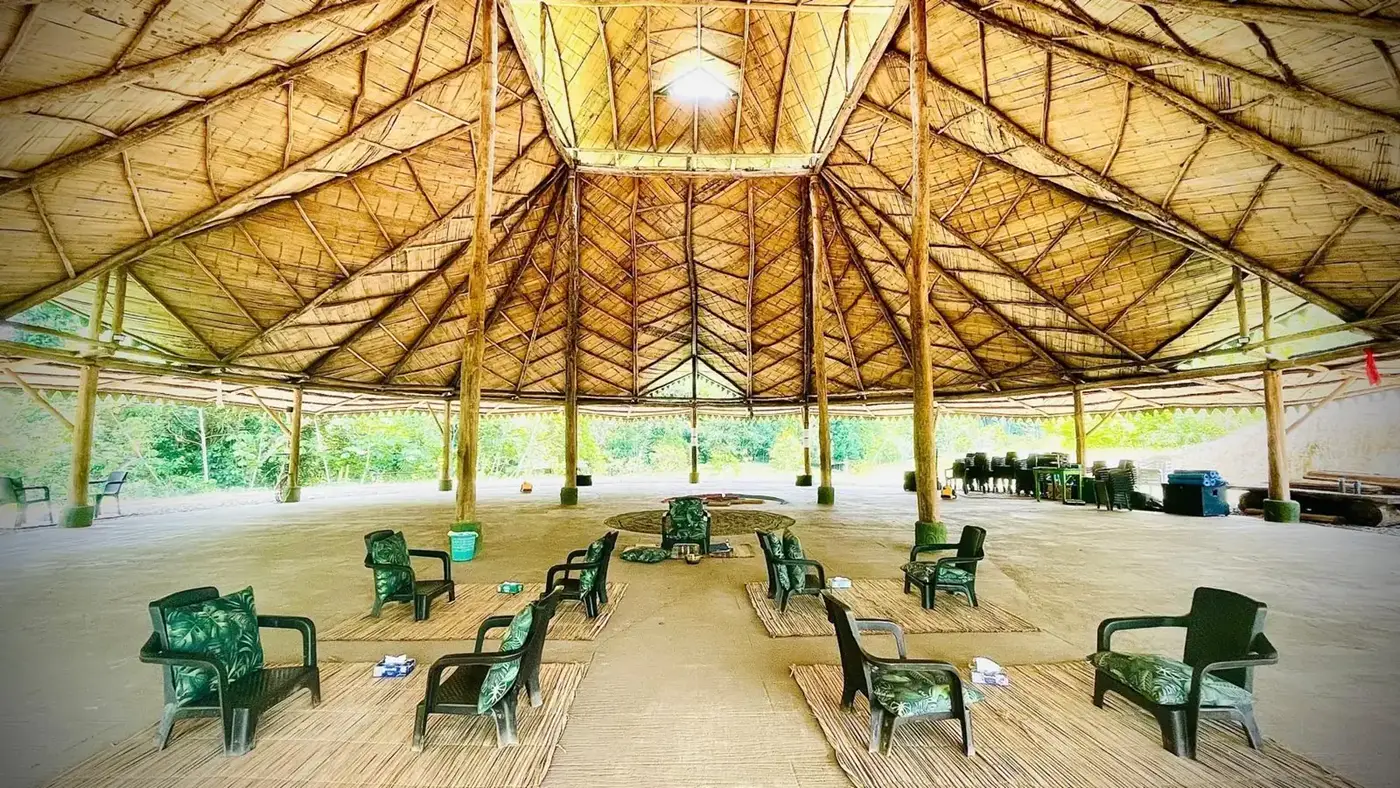 The EntreAguas gathering space, with a palm-thatched roof and open to the forest