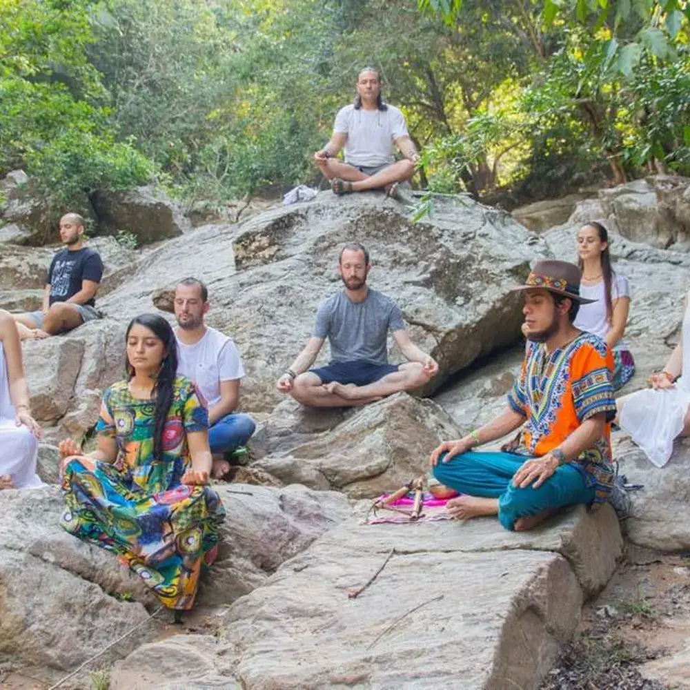 Group meditating on the river rocks