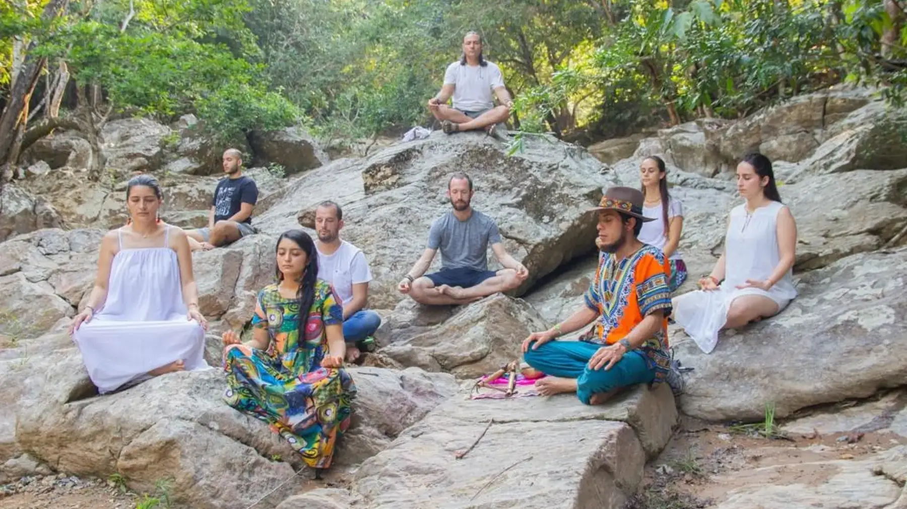Grupo en meditación sobre las rocas junto al bosque de EntreAguas